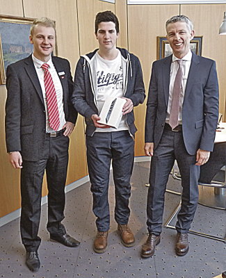 Filialdirektor Peter Scholzen, Jugendberater Damien Rowe mit dem glücklichen  Hauptgewinner Nicolas Krämer bei der Übergabe des Hauptpreises. 