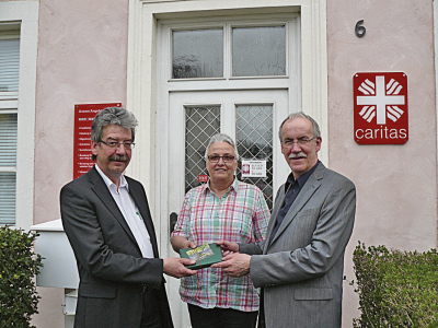 Katy Schug (Mitte) und Winfried Görgen (rechts) überreichen Alfred Steimers (links) zum Start in seine neue ehrenamtliche Tätigkeit als Vorsitzender des Caritasrats ein Buchgeschenk