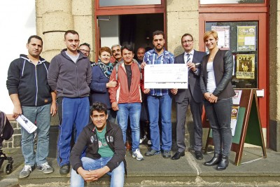 Besucher des Cafe Asyl freuen sich über die von Herbert Thelen und Annika Molitor übergebene Spende