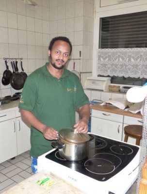 Salomon Gebre-Eyesus aus Eritrea bei der Essenszubereitung