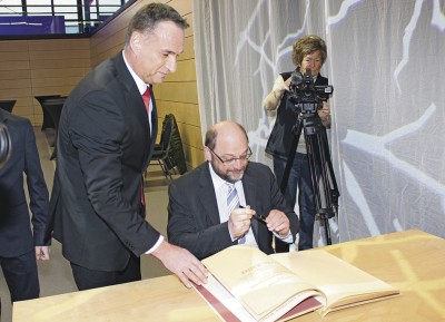 Martin Schulz, der aus terminlichen Gründen erst kurz vor der Preisverleihung direkt ins Eventum kam, trägt sich im Beisein von Bürgermeister Rodenkirch ein  