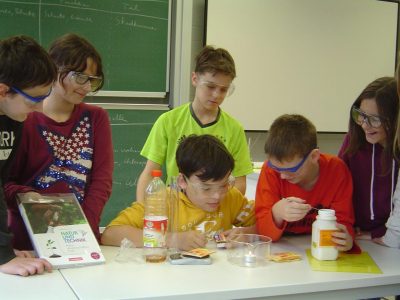 Das Bild zeigt  die Schüler der Klasse 6 während eines Versuchs im naturwissenschaftlichen Unterricht im neuen Chemiesaal.