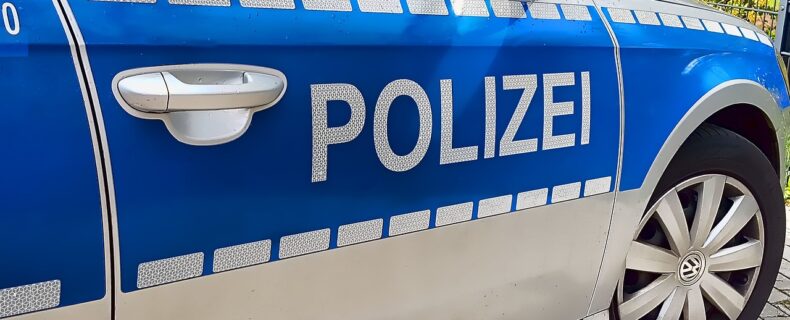 Die Tür eines Polizeiautos in Nahaufnahme inklusive Schriftzug POLIZEI.