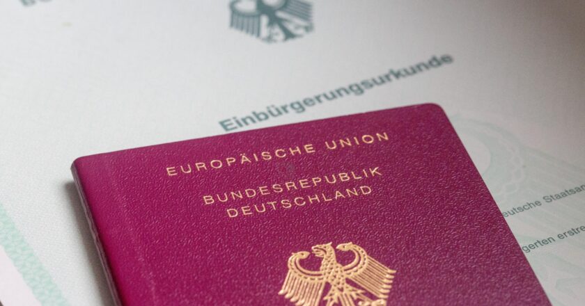 Ein Einbürgerungsurkunde der Bundesrepublik Deutschland und ein deutscher Reisepass liegen auf einem Tisch.