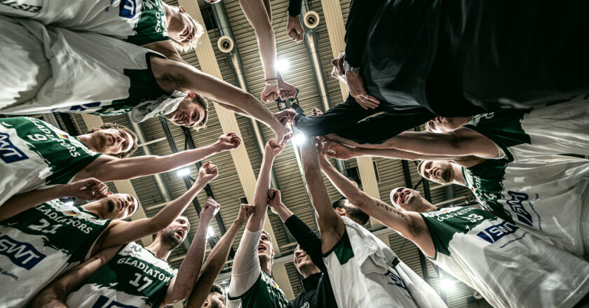 Eine Gruppe von Basketballern legt vor einem Spiel die Hände aufeinander.