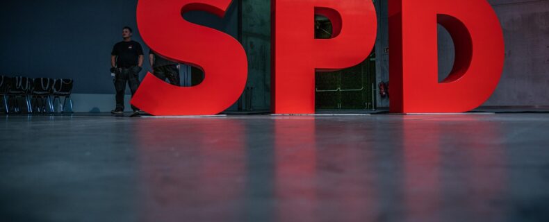 Ein Aufsteller des SPD-Logos leuchtet in den Parteifarben.